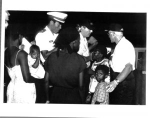 Interdiction of Haitians by U.S. Coast Guard, officials talk to women and children, October 1981. Source: United States Citizenship and Immigration Services History Office and Library.