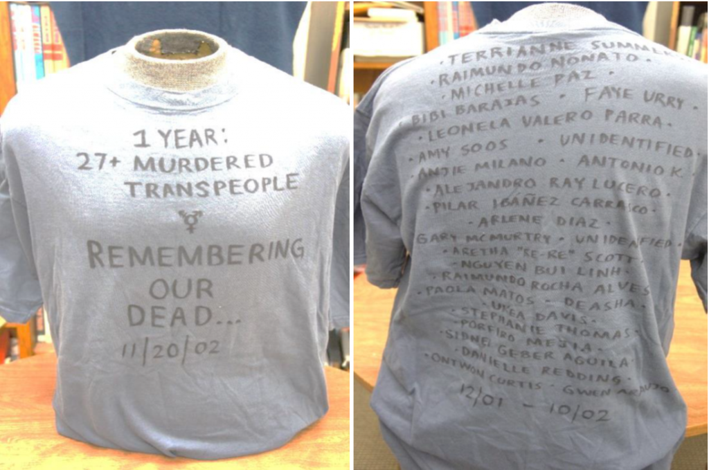 Image of front and back of shirt. Front reads" 1 Year: 27+ Murdered Transpeople" and "Remembering Our Dead..11/20/02" There is a list of names of trans people who were murdered